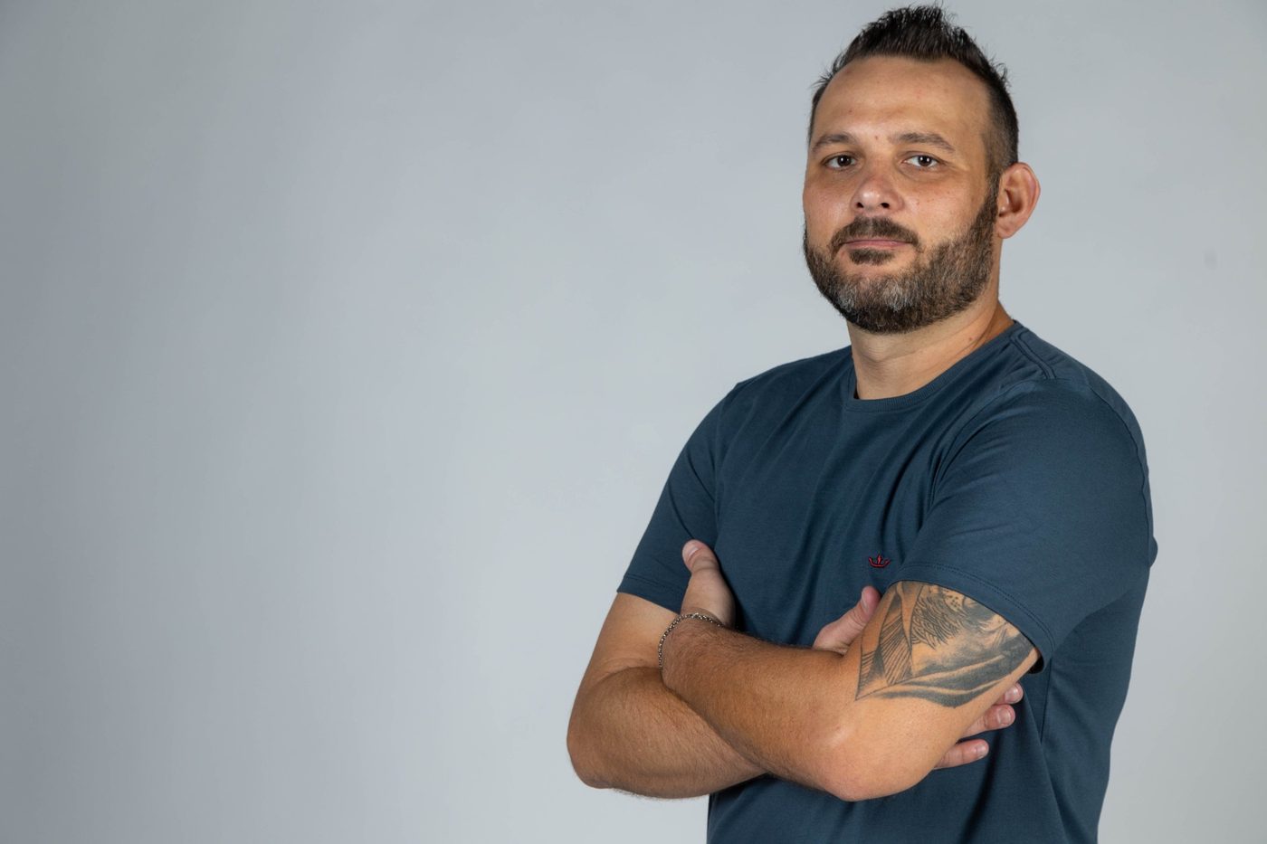 João Marcel Camargo de braços cruzados, olhando para a câmera